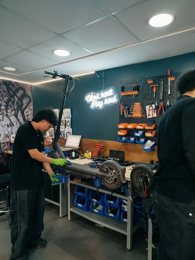 Técnico de Fixtore Gandía reparando patinete eléctrico en banco de trabajo