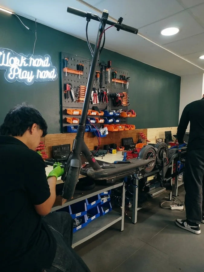 Interior del taller Fixtore Gandía con patinetes en reparación y zona de trabajo organizada